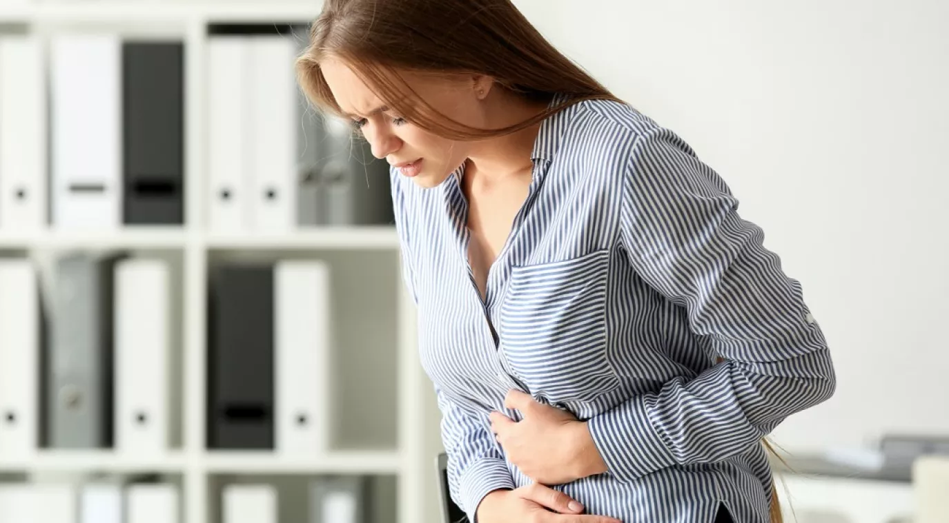 امرأة تعاني من ألم شديد في البطن بسبب التسمم الغذائي