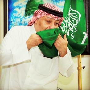 حسن البلام يقبل علم السعودية- الصورة من حسابه على الانستجرام