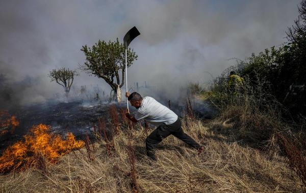 صورة لمواطن يحاول إخماد حريق في إسبانيا